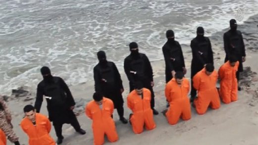 Still image from video shows men purported to be Egyptian Christians held captive by the Islamic State kneeling in front of armed men along a beach said to be near Tripoli